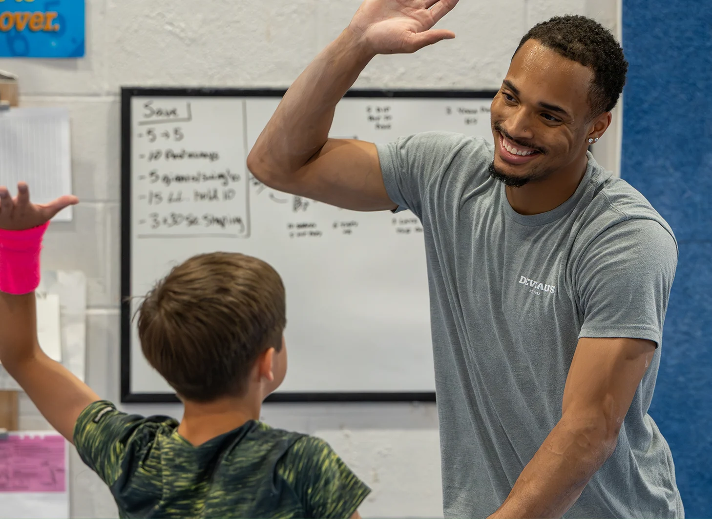 Boy gymnastics team coach high fiveing team member